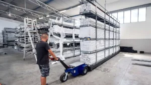 Zallys elektromos vontató ipari raktárban, nehéz rakomány vontatása közben