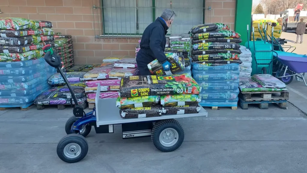 Zallys elektromos vontató nehéz ipari rakomány mozgatása közben raktári környezetben